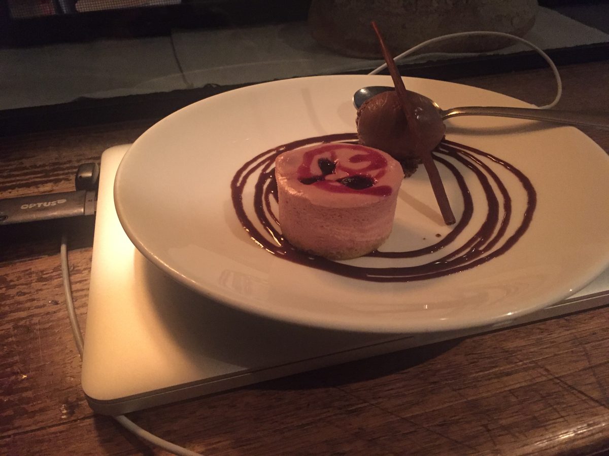 A very rich chocolate dessert sitting on a plate atop a laptop
