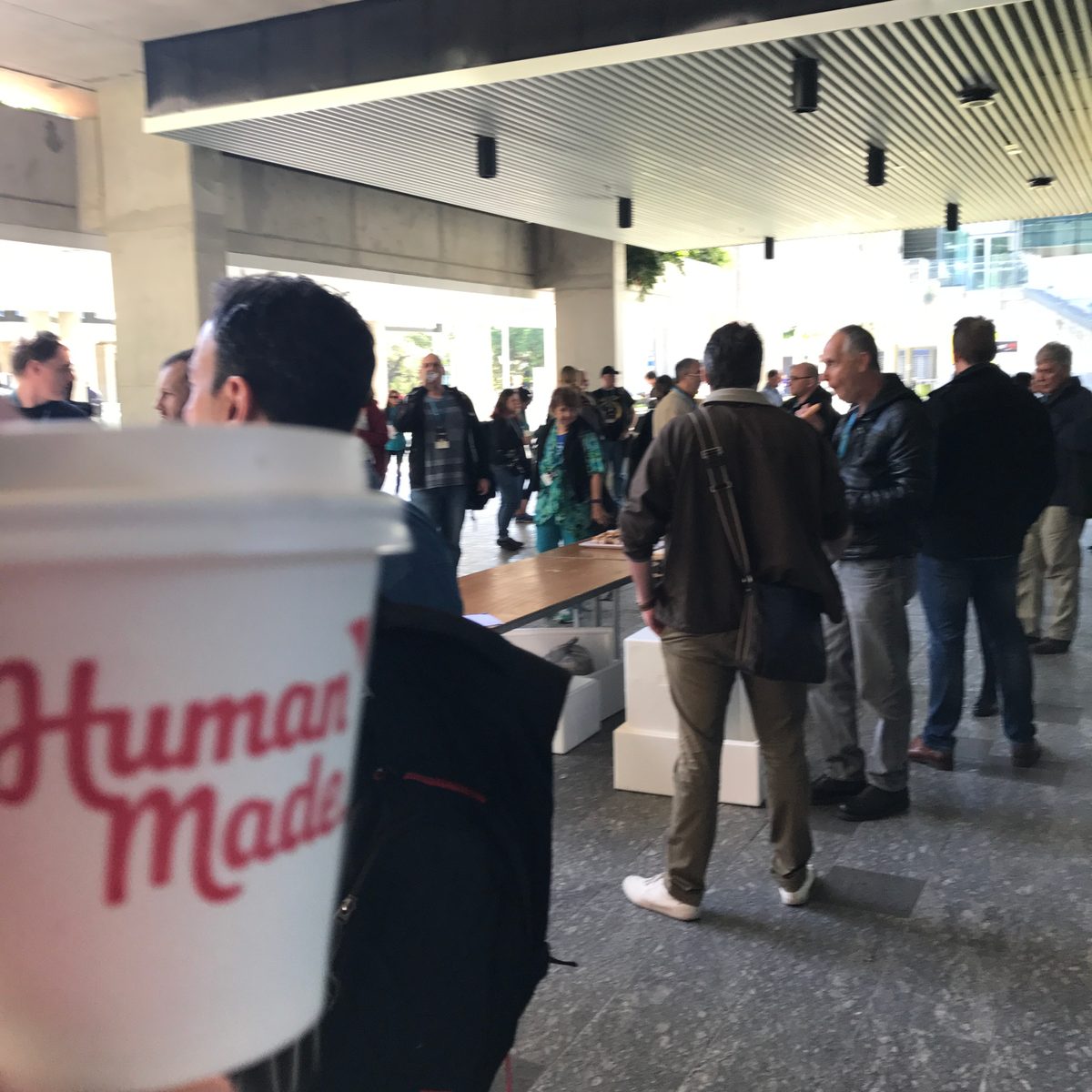 Coffee cup stamped with Human Made logo in a conference setting