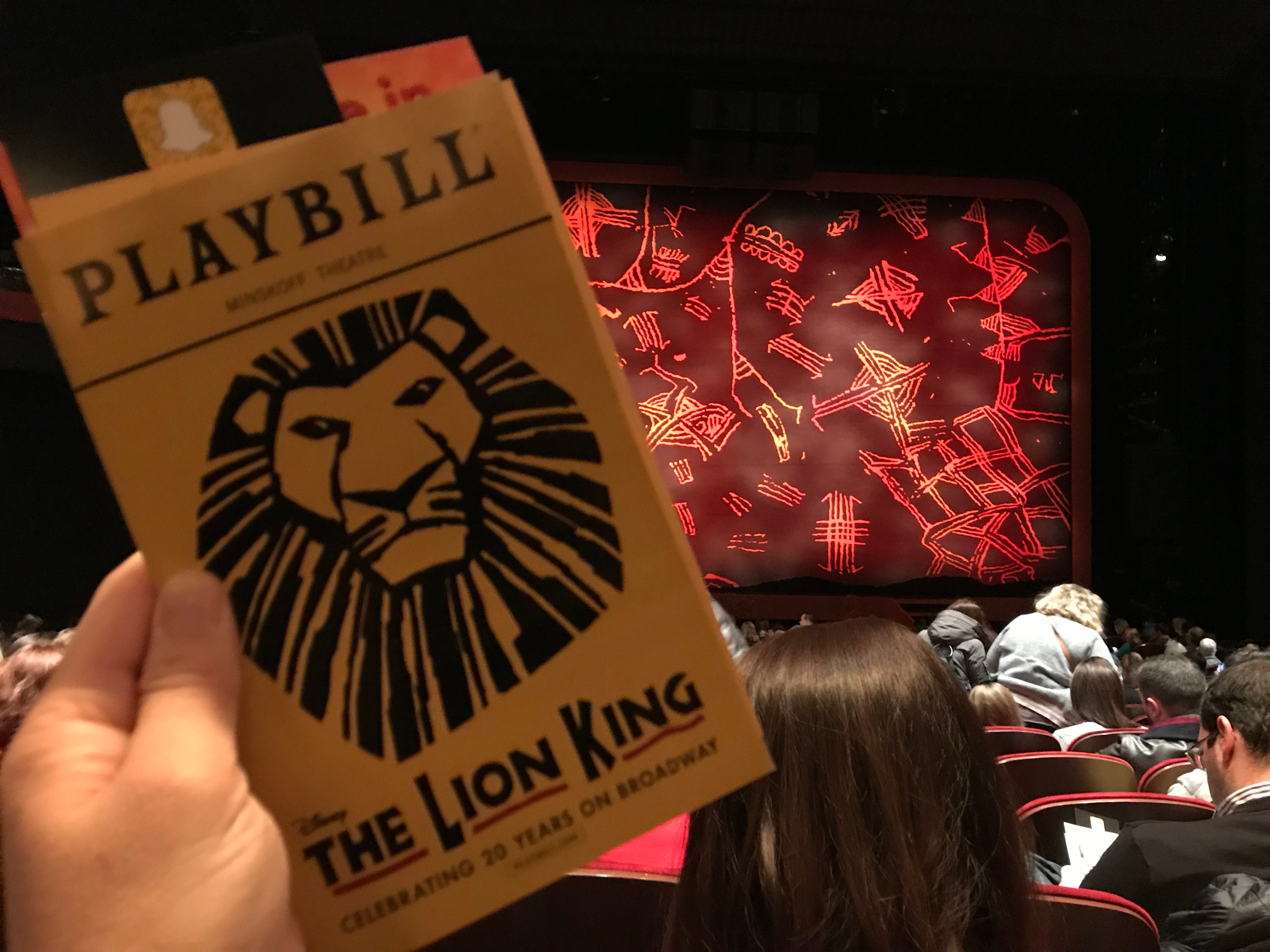 The Lion King playbill cover with the stage in the backgroun