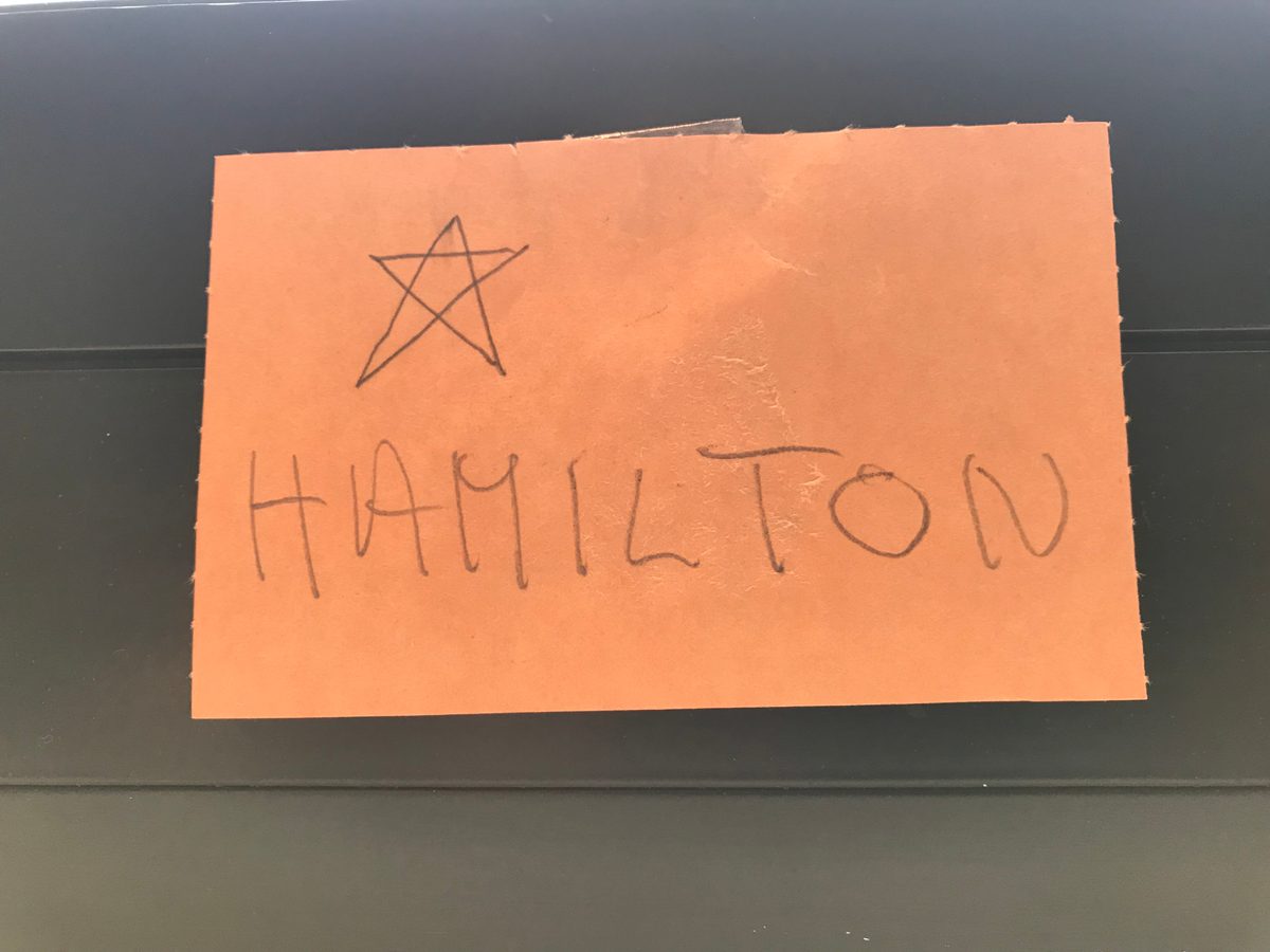 A post it note with a hand drawn star and Hamilton written in all caps