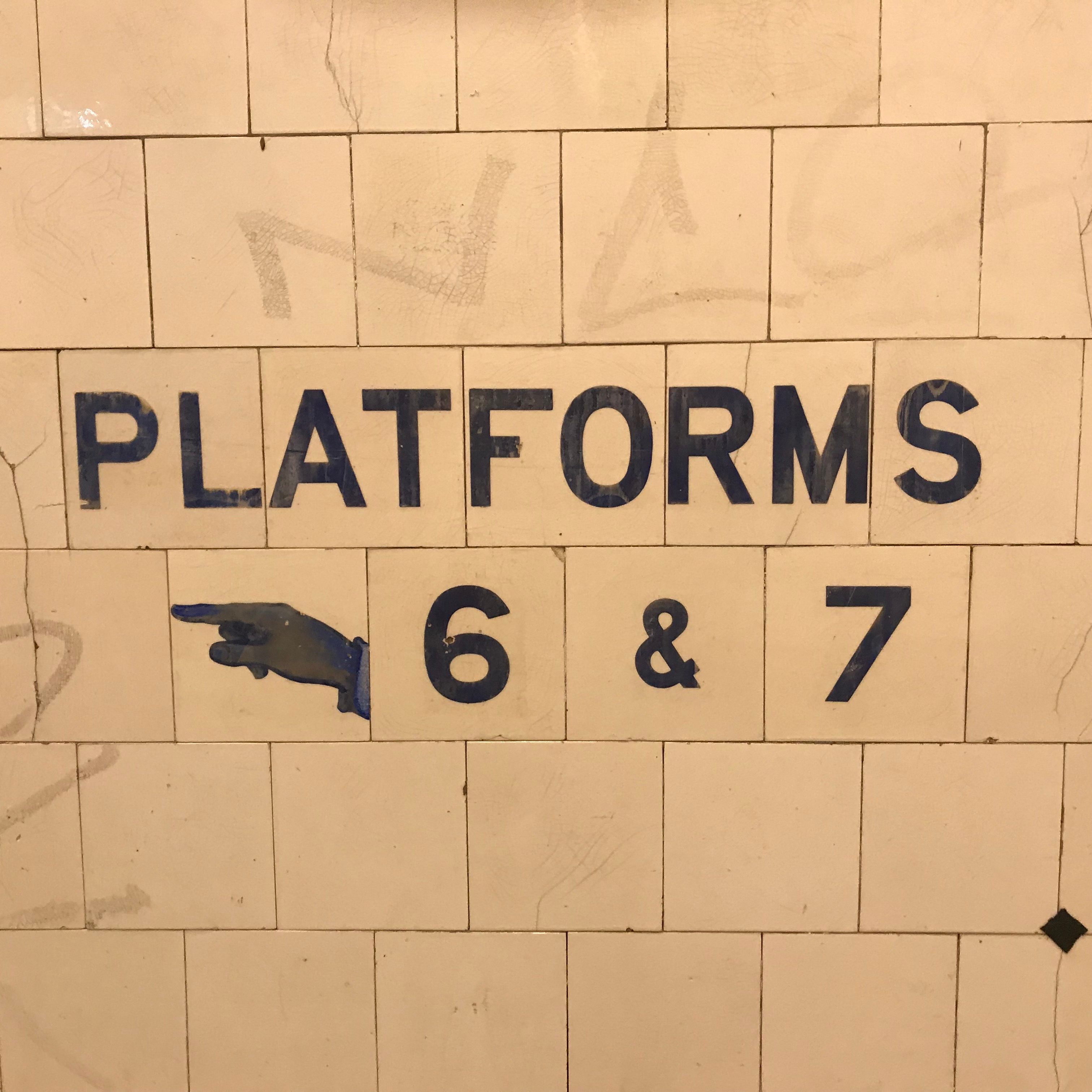 Older style sign directing people to railway station platforms.