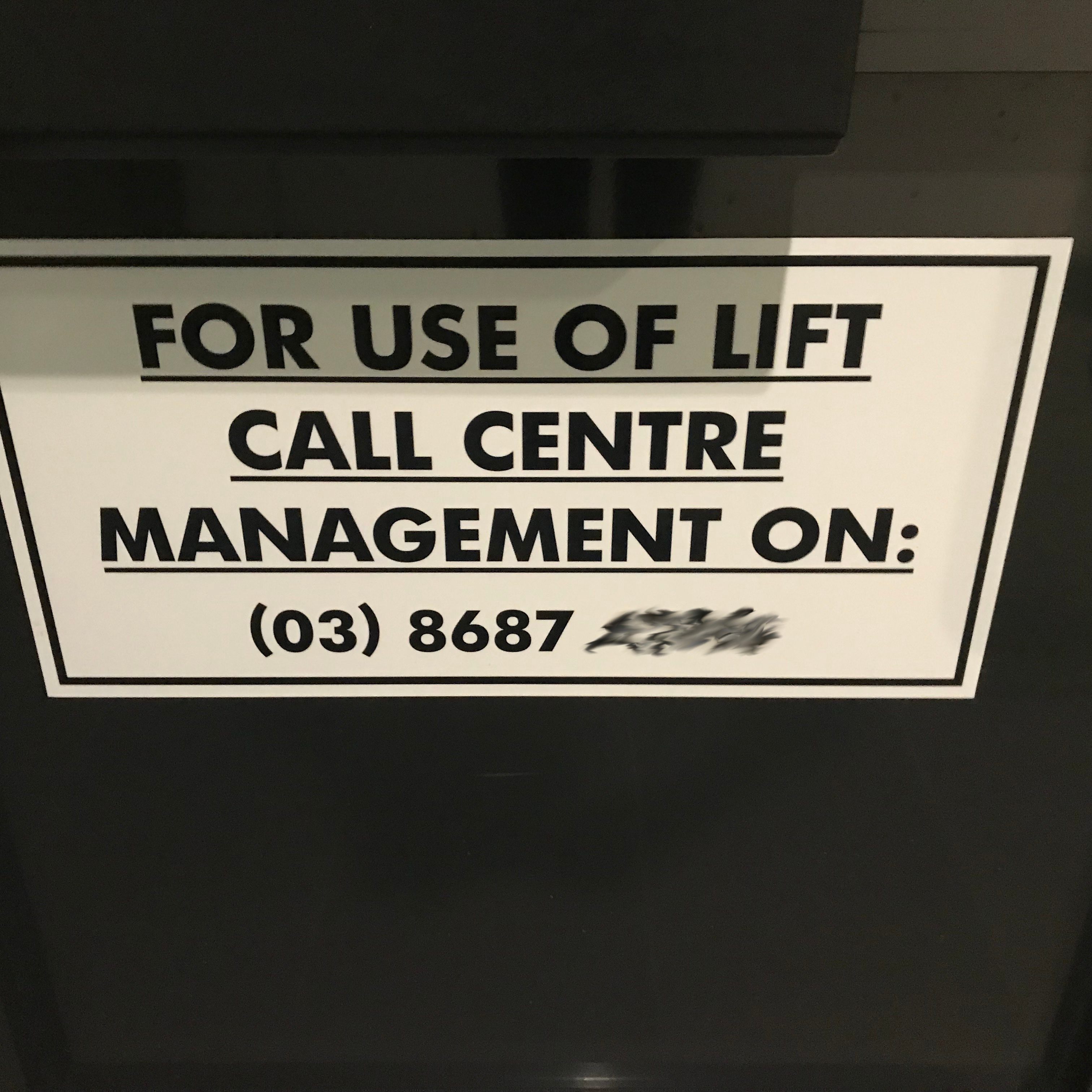 Sign: For use of lift call centre management on a blurred phone number.