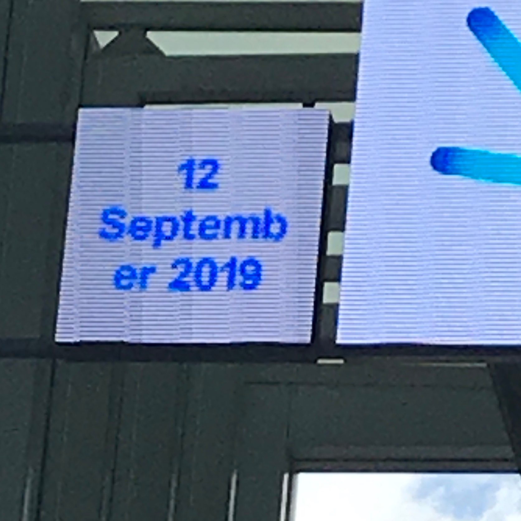 Electronic date display with a line break in the month's name.