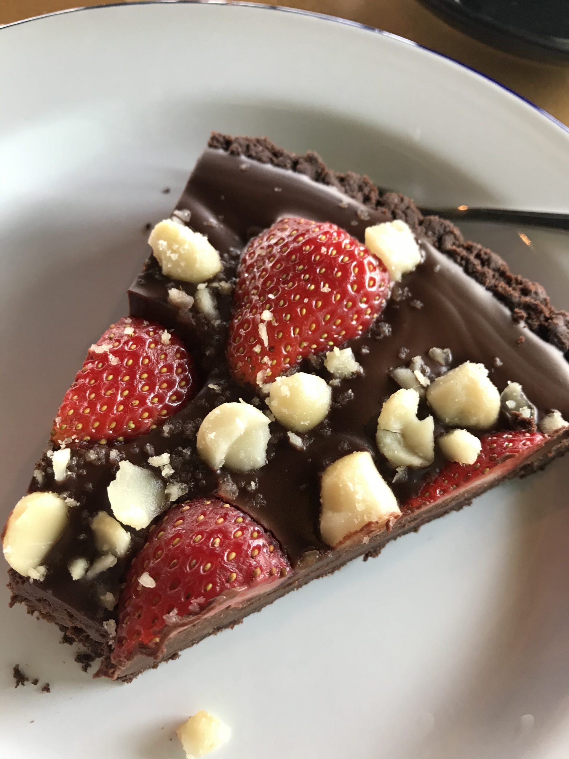 A very rich chocolate cake with nuts and berries on top