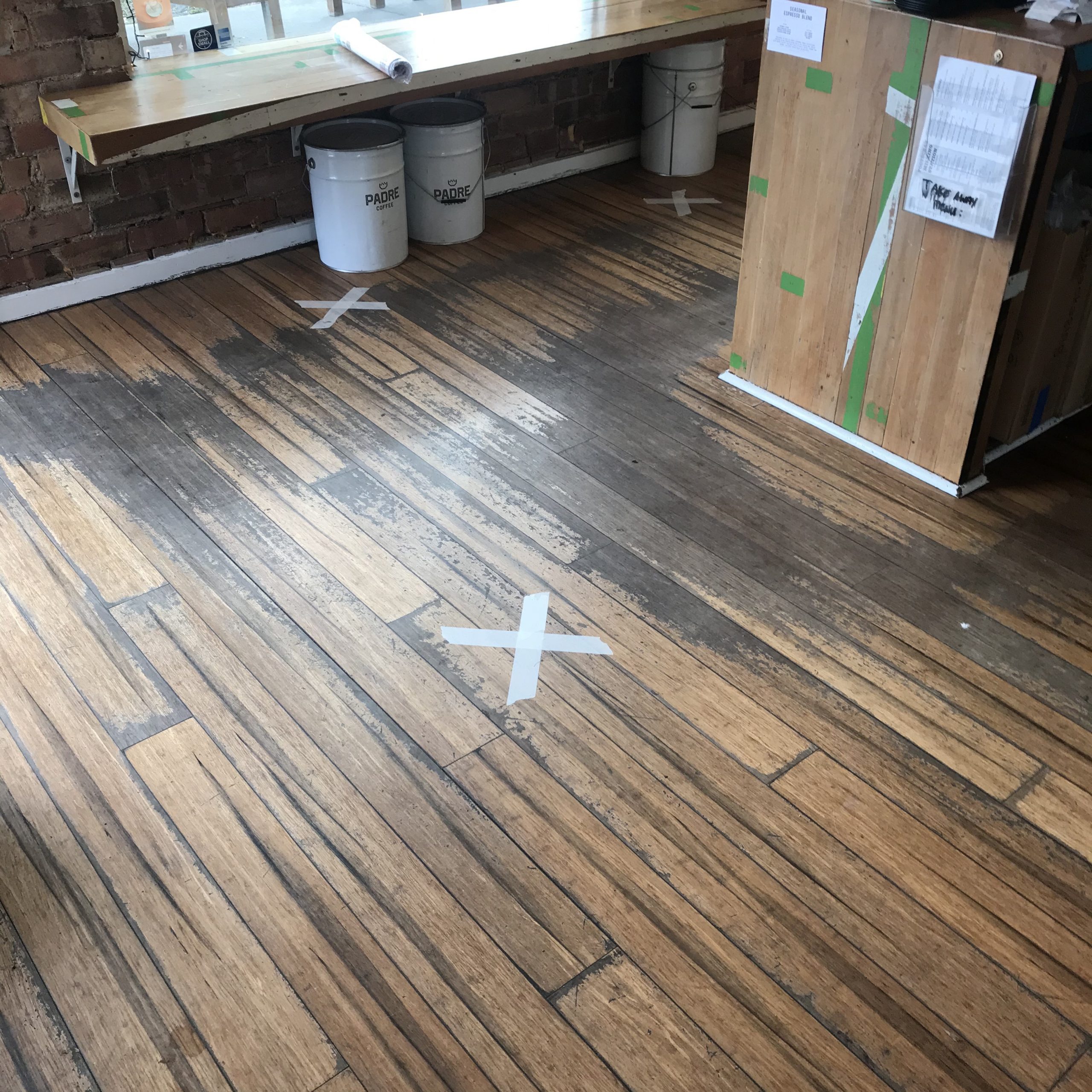 Floor with white crosses indicating where people should stand to maintain social distancing.