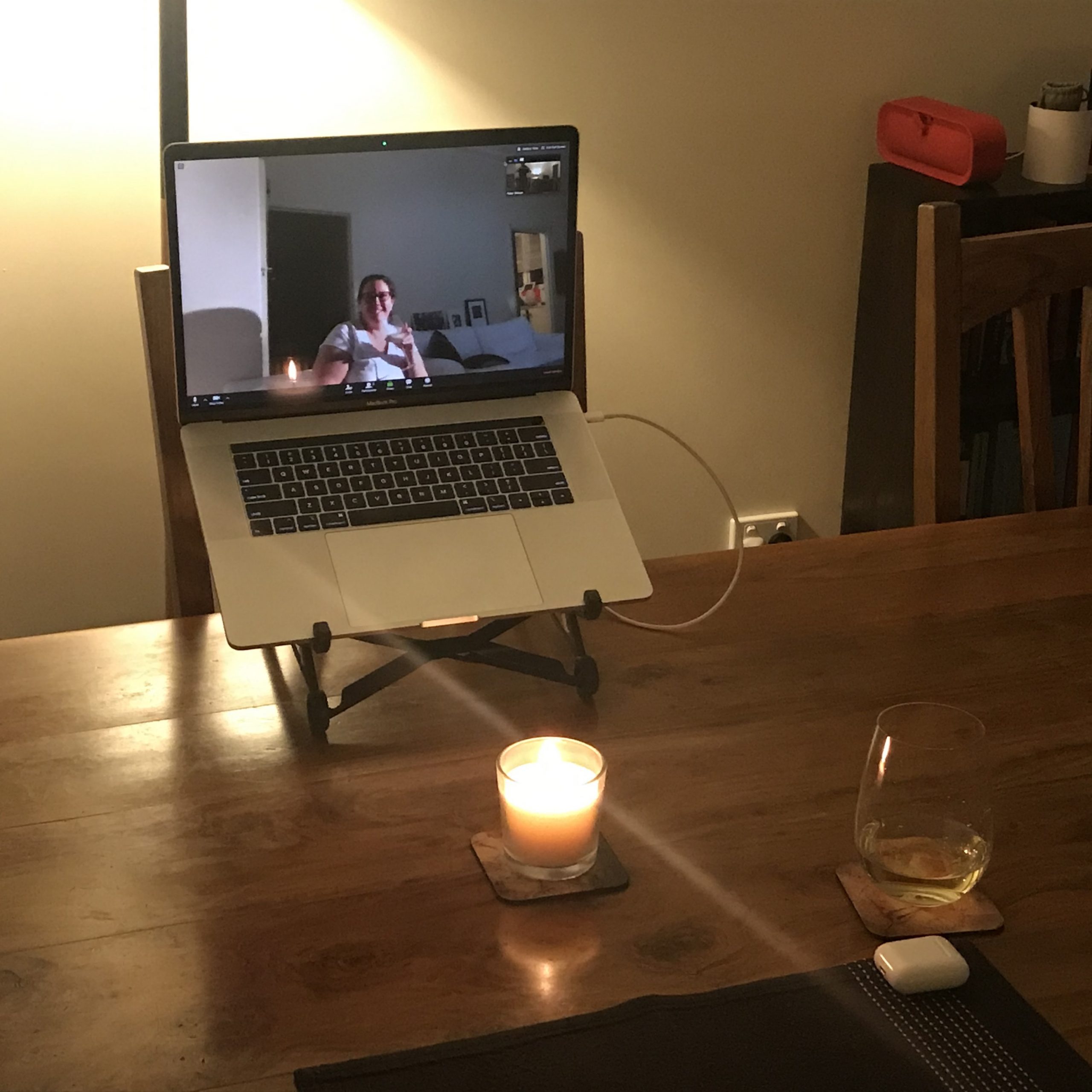 Dinner table set for one with laptop displaying a video call.