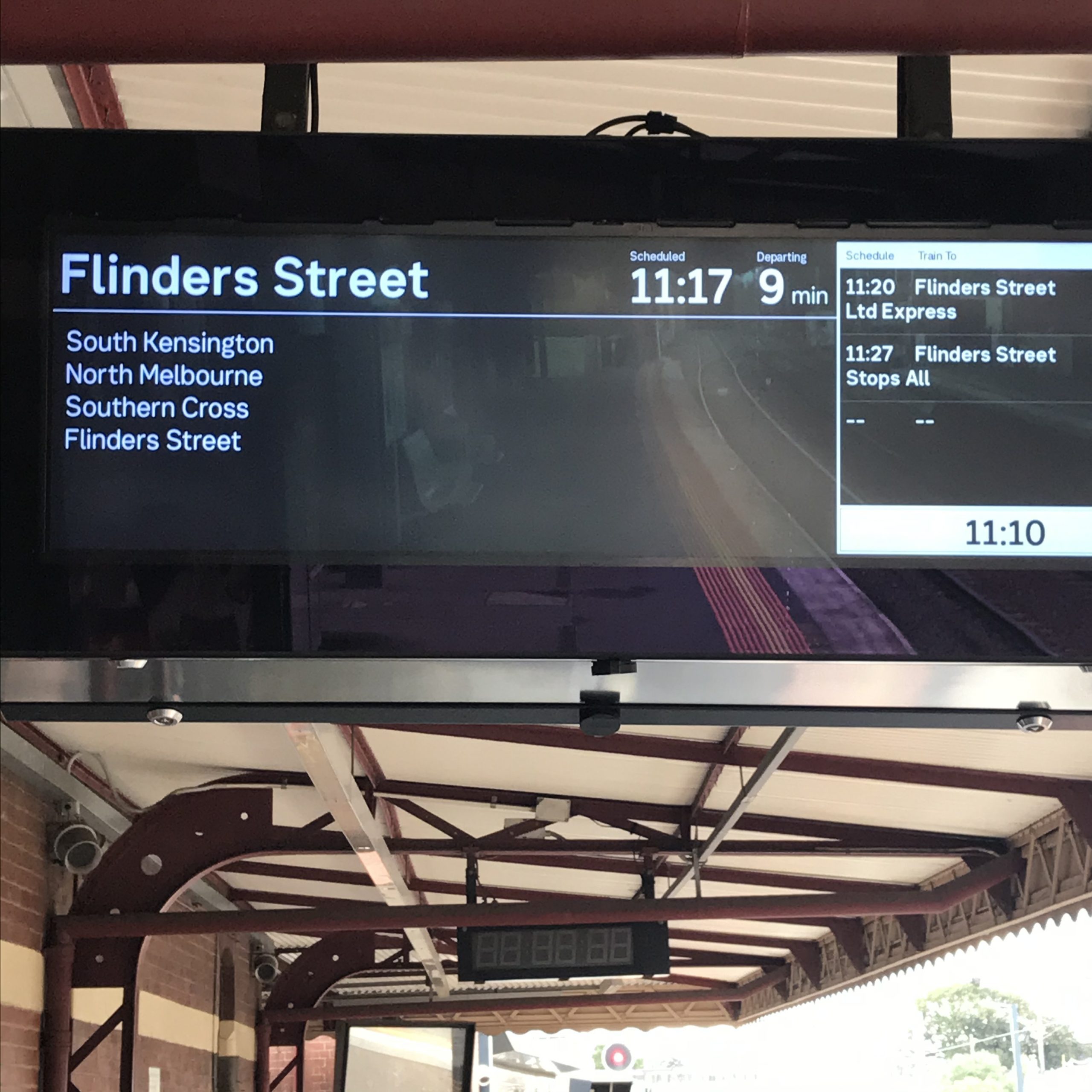 Railway sign showing departure time of Flinders Street train.
